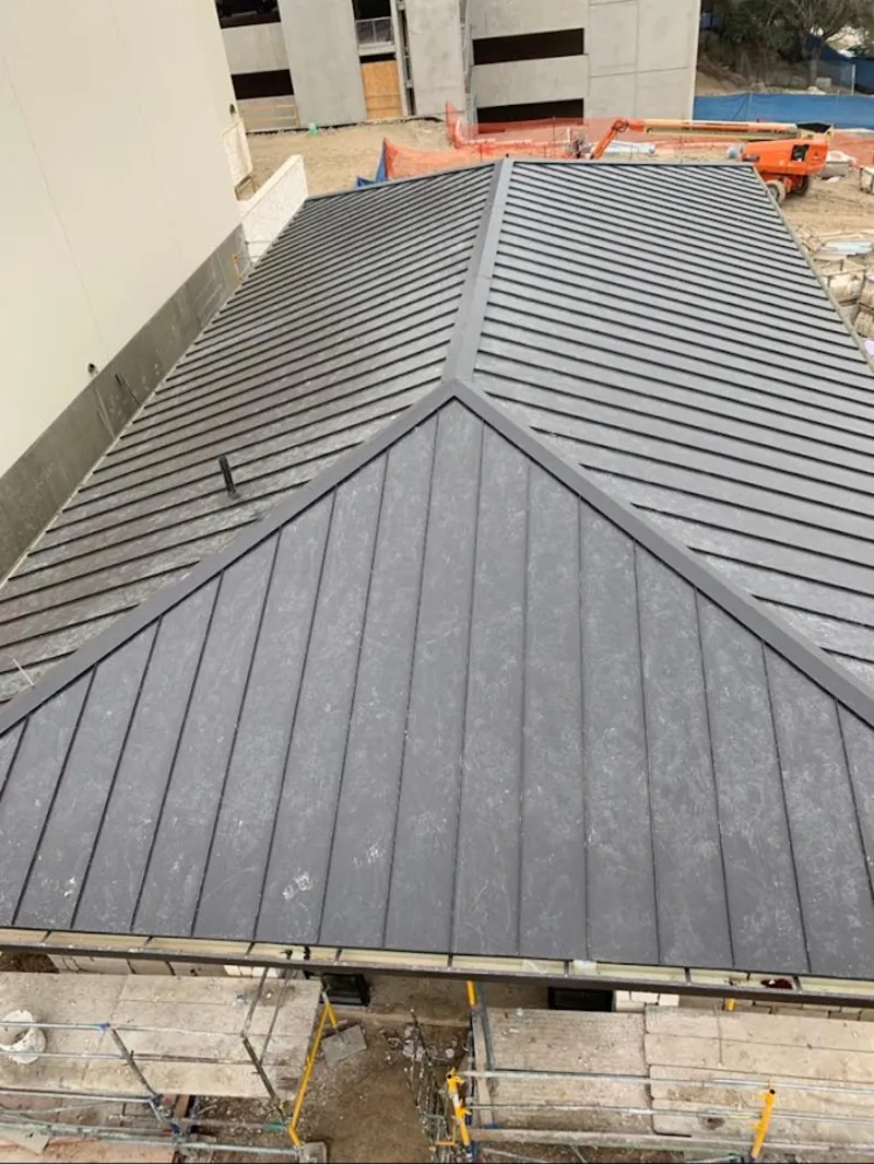 Commercial metal roof construction with crane equipment in Lynbrook